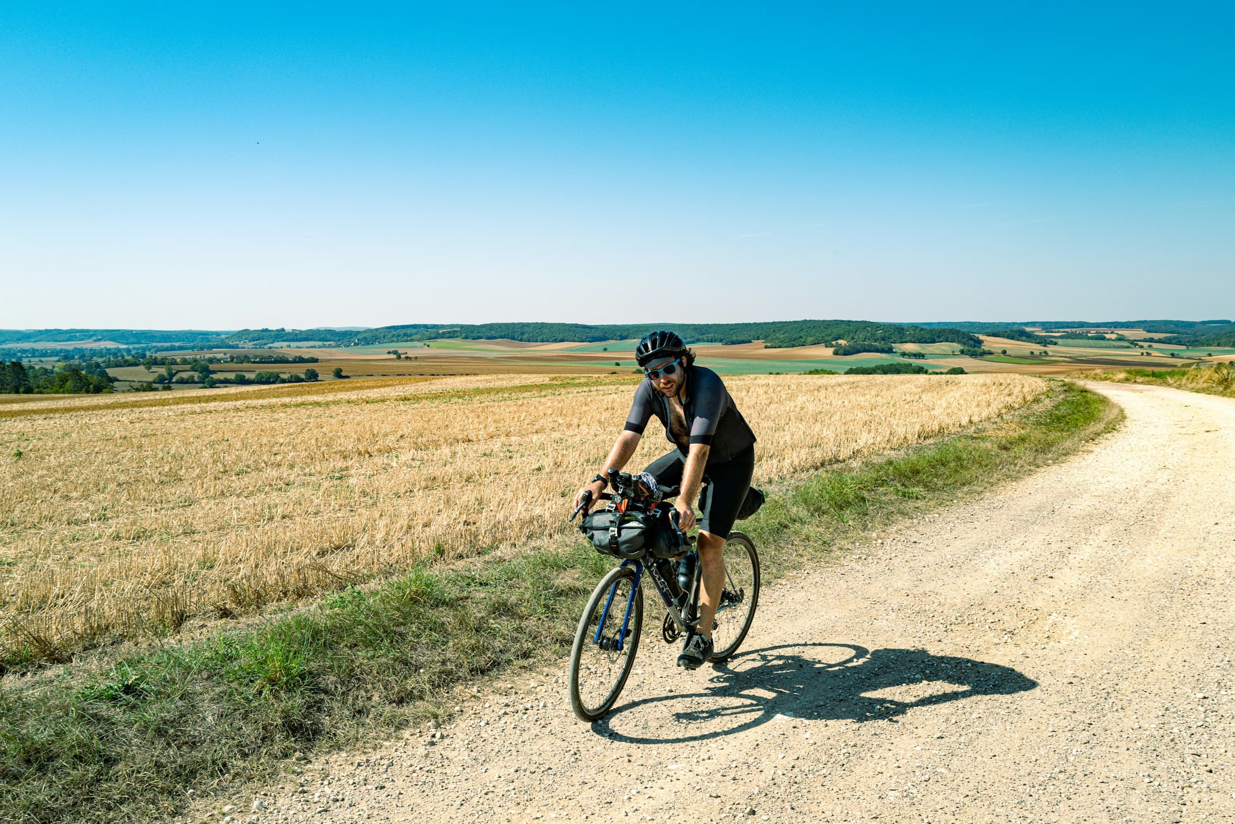 Fietser op een landweg door de velden
